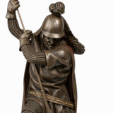 Bronze statue of a warrior holding a spear on a white background
