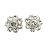 A pair of silver-colored floret-shaped stud earrings embellished with clear crystals.