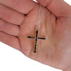 The Jewelled Cross necklace held in hand for scale